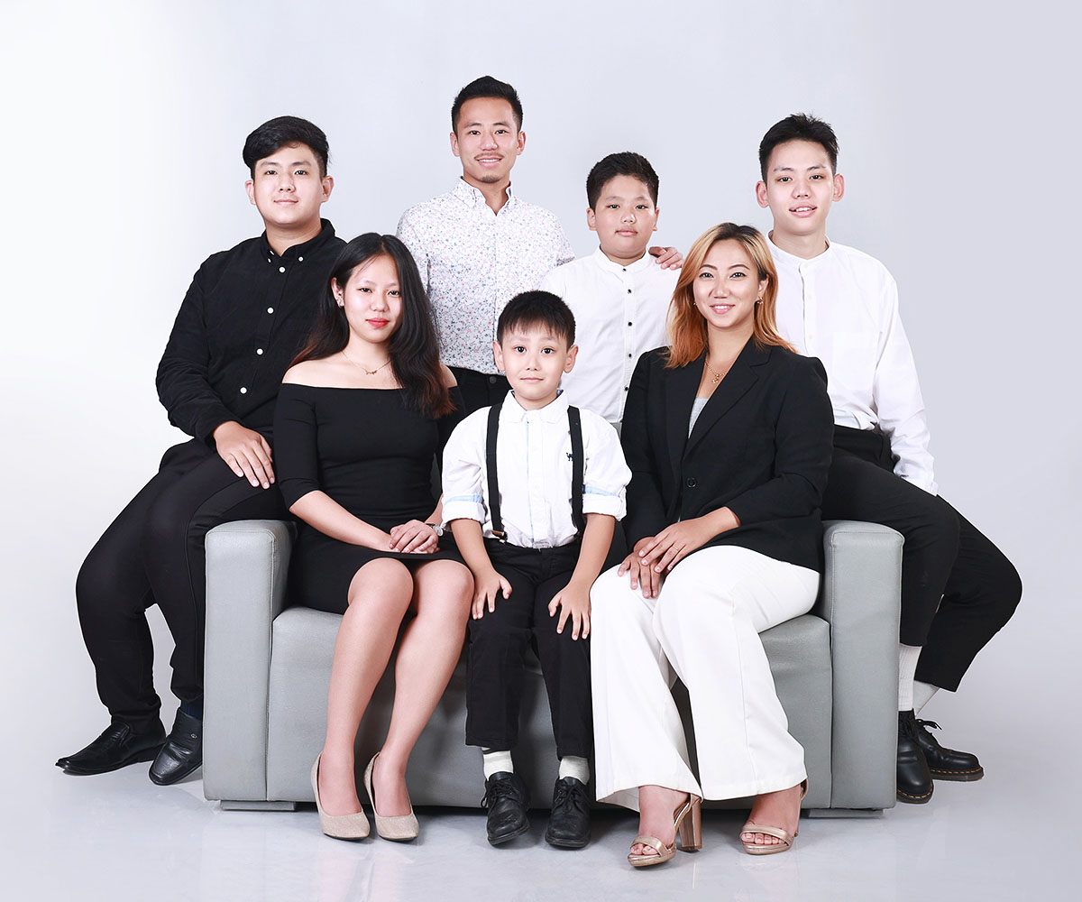 Studio family portrait in Kathmandu – group of seven in coordinated black and white outfits, posing for a professional photo session at Graduation Photo Studio.